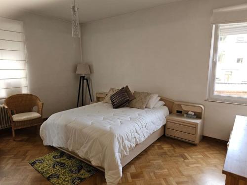 um quarto com uma cama branca e uma janela em Elegance ,Space & Luxury in Brussels em Bruxelas