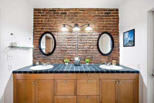 a bathroom with two sinks and a brick wall at NEW Downtown Denver City Loft-Great Walkability in Denver