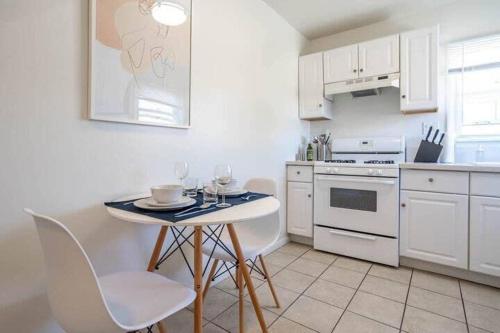 a white kitchen with a table with wine glasses on it at Very Peaceful 2BR with Desks & Super Fast Wifi in Los Angeles