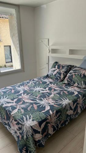 une chambre avec un lit avec une couette colorée et une fenêtre dans l'établissement Maison de ville à 3 kilometre du centre de cognac , jacuzzi privée et disponible sur place, à Saint-Brice