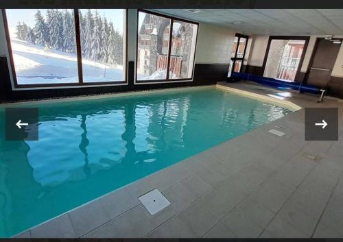 - une piscine dans un bâtiment avec 2 fenêtres dans l'établissement Le 340 C super besse 2 nuits minimum, à Besse-et-Saint-Anastaise