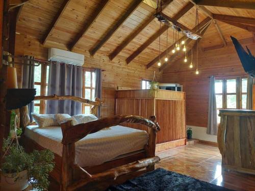 1 dormitorio con 1 cama en una habitación de madera en Villa con Hermosa Vista a las Montañas a Pasos del Río @drvacationsrental en Bonao