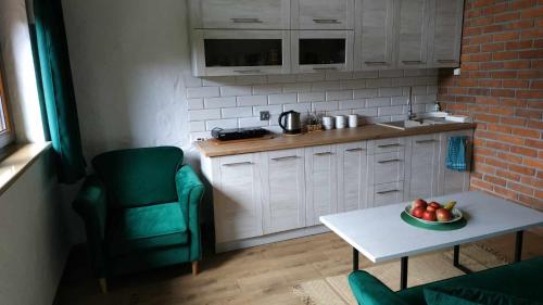 a kitchen with a bowl of fruit on a table at Domek z kominkiem, Ukta 63, Mazury, in Ruciane-Nida