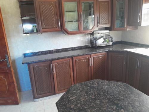a kitchen with wooden cabinets and a black counter top at منزل ابو يوسف القضاة in Ajloun