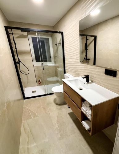 a bathroom with a sink and a shower and a toilet at El Reloj De La Villa in Valdefuentes