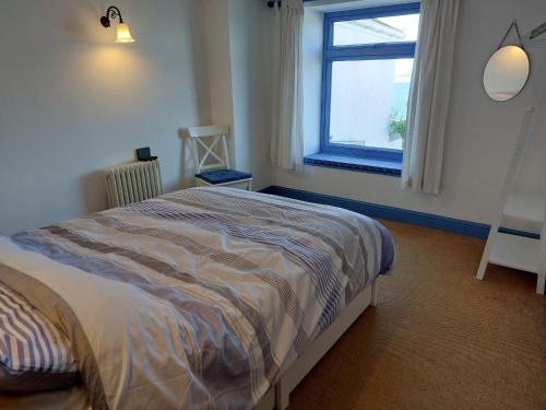 um quarto com uma cama e uma janela em 2 Bed cottage in a fantastic sea front setting em Appledore