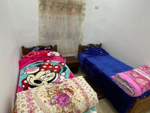 two twin beds in a room with at Dar Alaa in Tozeur