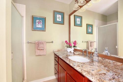 ein Badezimmer mit Waschbecken und großem Spiegel in der Unterkunft Manualoha 101 in Kipu