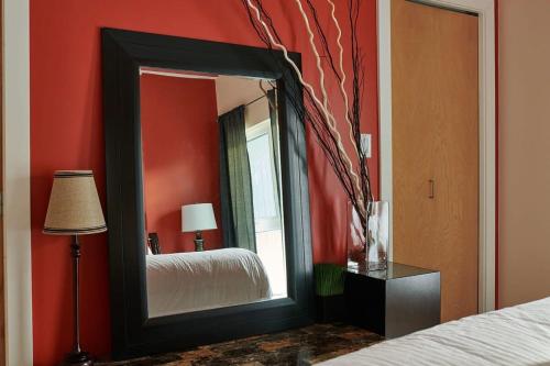 espejo en un dormitorio con cama y lámpara en NN - The Kit - Downtown 1-bed 1-bath, en Whitehorse