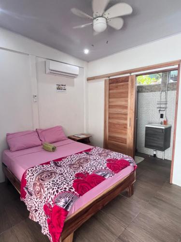 a bedroom with a large bed with red flowers on it at Apartamentos en el Centro de Puerto Viejo in Puerto Limón