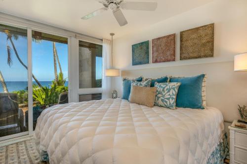 a bedroom with a bed with a view of the ocean at Poipu Makai E1 in Koloa