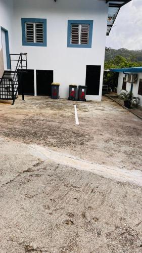 a parking lot in front of a white building at Blue Home2 T3 meublé à Matoury pour 1 à 6 voyageurs. in Matoury