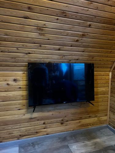 a flat screen tv in a wooden wall at ECO PARK ASPAN in Almaty