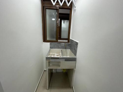 La salle de bains est pourvue d'un lavabo et d'un miroir. dans l'établissement Apartaloft en el centro 104, à Pereira