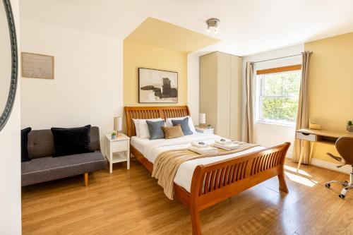 1 dormitorio con 1 cama y 1 sofá en Charming 2BR Flat, Holloway Road en Londres
