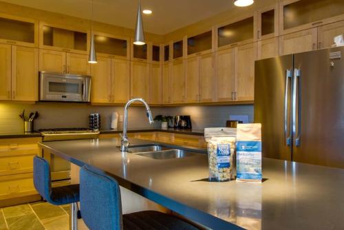 a kitchen with a counter with a sink and a refrigerator at NN - Park View #1 - Downtown 2-bed 2-bath in Whitehorse