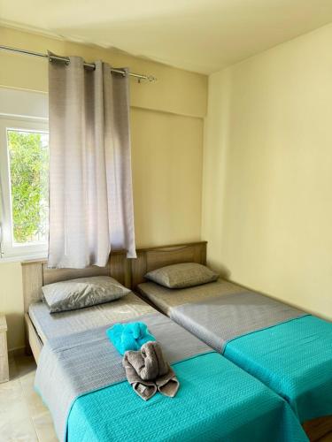 zwei Betten mit Handtüchern in einem Schlafzimmer in der Unterkunft Adoniss apartmentss 1 in Paralia Dionisiou