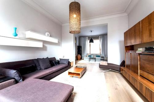 un soggiorno con divano e tavolo di 3 bedrooms apartement with enclosed garden and wifi at Bruxelles a Bruxelles