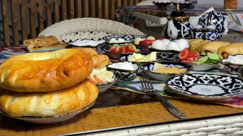 una mesa cubierta con muchos tipos diferentes de pan en Mahbubakhon Hotel, en Bukhara