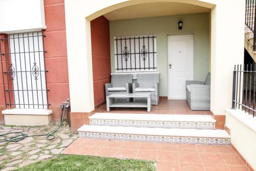 a house with two chairs on the front porch at Apartment Altos De La Bahia X in Torrevieja