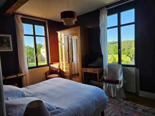 Schlafzimmer mit einem Bett, einem Schreibtisch und Fenstern in der Unterkunft Domaine de Belcayre in Montauban