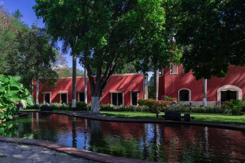 BacaにあるHacienda Kancabchénの前に池がある赤い建物