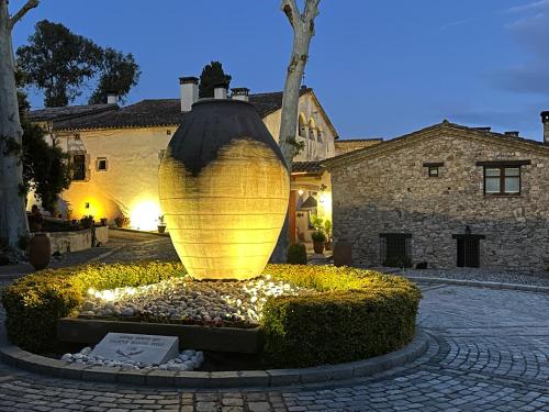 a large yellow vase sitting in the middle of a courtyard at Masia Can Viver - Olive oil tourism B&B in Bigues i Riells