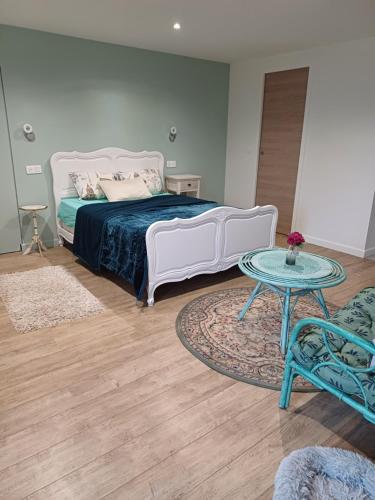 ein Schlafzimmer mit einem weißen Bett und einem Tisch in der Unterkunft un petit studio moderne et conviviale 