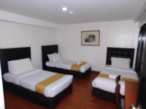 two beds in a hotel room with two beds at Hotel Casa Navi in Bogotá