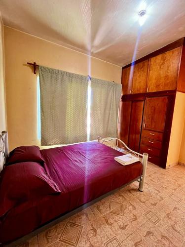 ein Schlafzimmer mit einem Bett mit violetter Bettwäsche und einem Fenster in der Unterkunft La casa de doña Juanita 