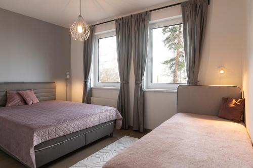 1 dormitorio con 2 camas y ventana en Tölgyes Villa, en Kőszeg