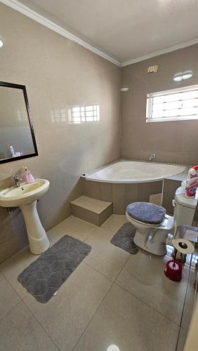 a bathroom with a tub and a toilet and a sink at Artem Apartments - Apartment 1 in Kitwe