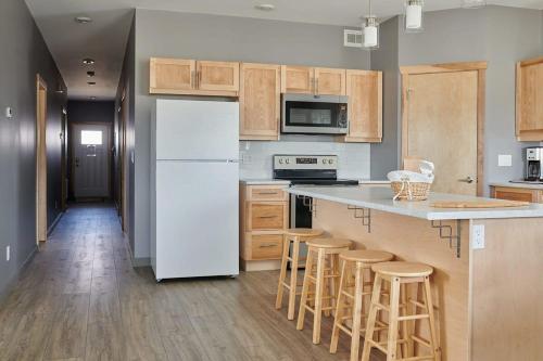 a kitchen with a white refrigerator and wooden cabinets at NN - The Kluane - Whistlebend 3-bed 2-bath in Whitehorse