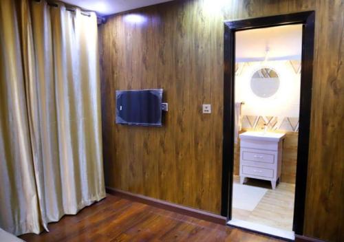 a room with a door with a television and a sink at Bahria Prime Apartments in Lahore