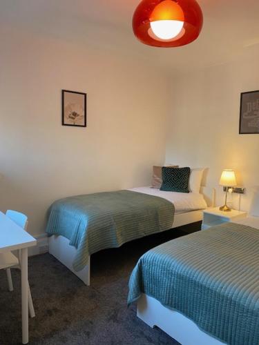 a bedroom with two beds and a red light at CAMDEN TOWN PARKWAY ROOMS in London