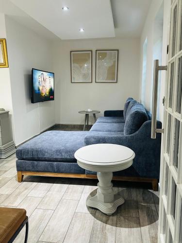 a living room with a blue couch and a table at Village at 17 in Gaborone