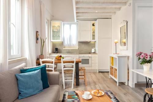 een woonkamer en keuken met een bank en een tafel bij CasaNova Corfu old town center in Corfu-stad