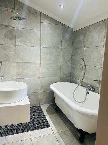 a bathroom with a white tub and a sink at Village at 17 in Gaborone