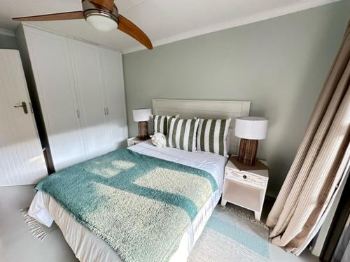 a bedroom with a bed with a blue blanket on it at Modern Beachfront Home in Westbrook