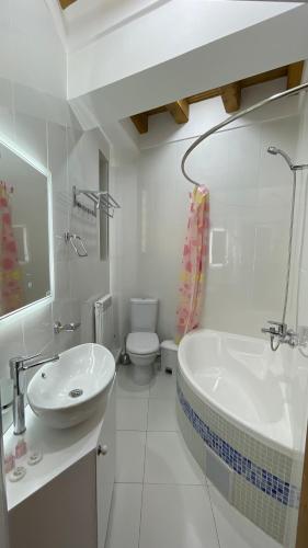 a bathroom with a sink and a tub and a toilet at Mahbubakhon Guest house in old city in Bukhara