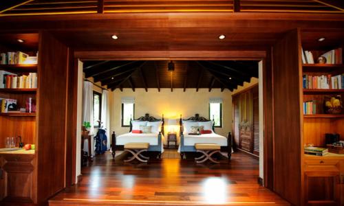 a bedroom with two beds in a room with bookshelves at Royal Isabela in Isabela