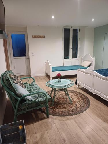 ein Wohnzimmer mit einem Sofa, einem Tisch und Stühlen in der Unterkunft un petit studio moderne et conviviale 