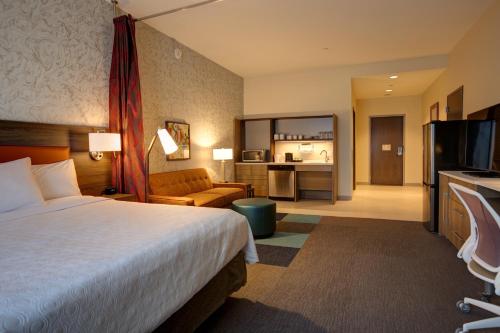 a hotel room with a bed and a living room at Home2 Suites By Hilton Charlotte Uptown in Charlotte