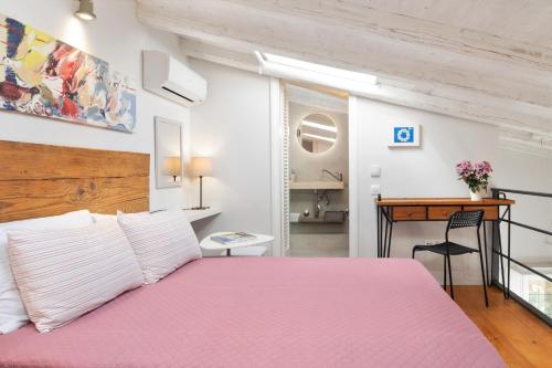 een slaapkamer met een roze bed en een bureau bij CasaNova Corfu old town center in Corfu-stad