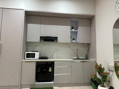 a kitchen with white cabinets and a microwave at Your homely studios in Ghaziabad
