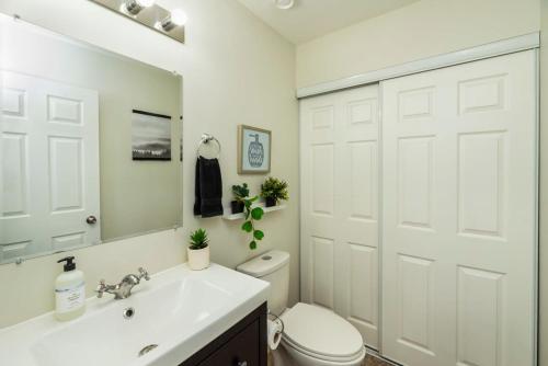 een witte badkamer met een toilet en een wastafel bij NN The Homestay Crestview 2bed 1 5bath in Whitehorse