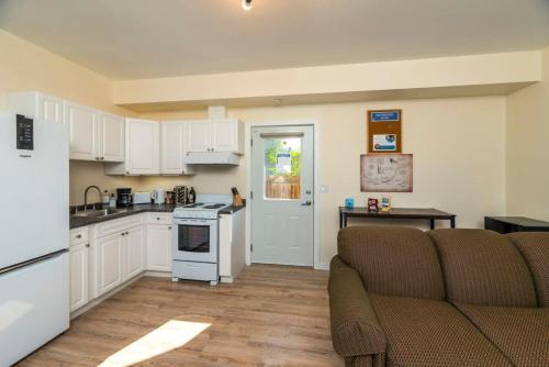 a kitchen with white cabinets and a couch in a room at NN The Lavendar B Whistlebend 1bed 1bath in Whitehorse
