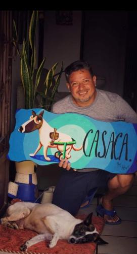 a man holding a sign that says casa with two dogs at Casaca in Concepción de Ataco