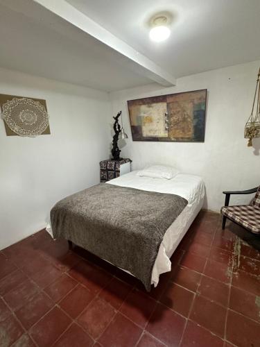 um quarto com uma cama e uma cadeira em Casaca em Concepción de Ataco