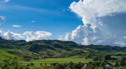 a view of a green valley with clouds at Ban Raiphudin in Khao Kho